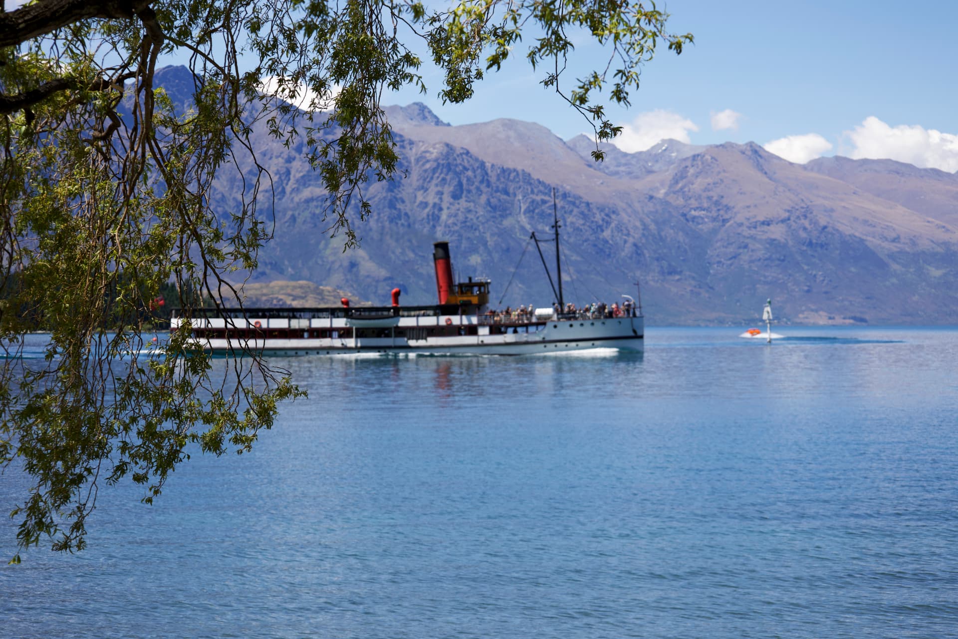 The TSS Earnslaw steamship cruising on Lake Wakatipu with the Remarkables mountain range behind, Queenstown, New Zealand